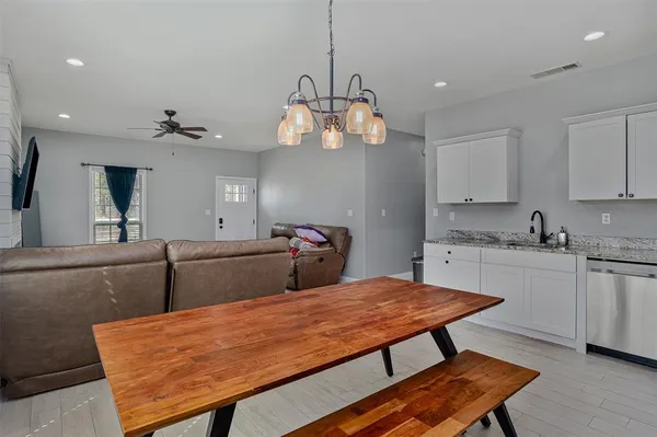 a room with stainless steel appliances kitchen island granite countertop wooden floor