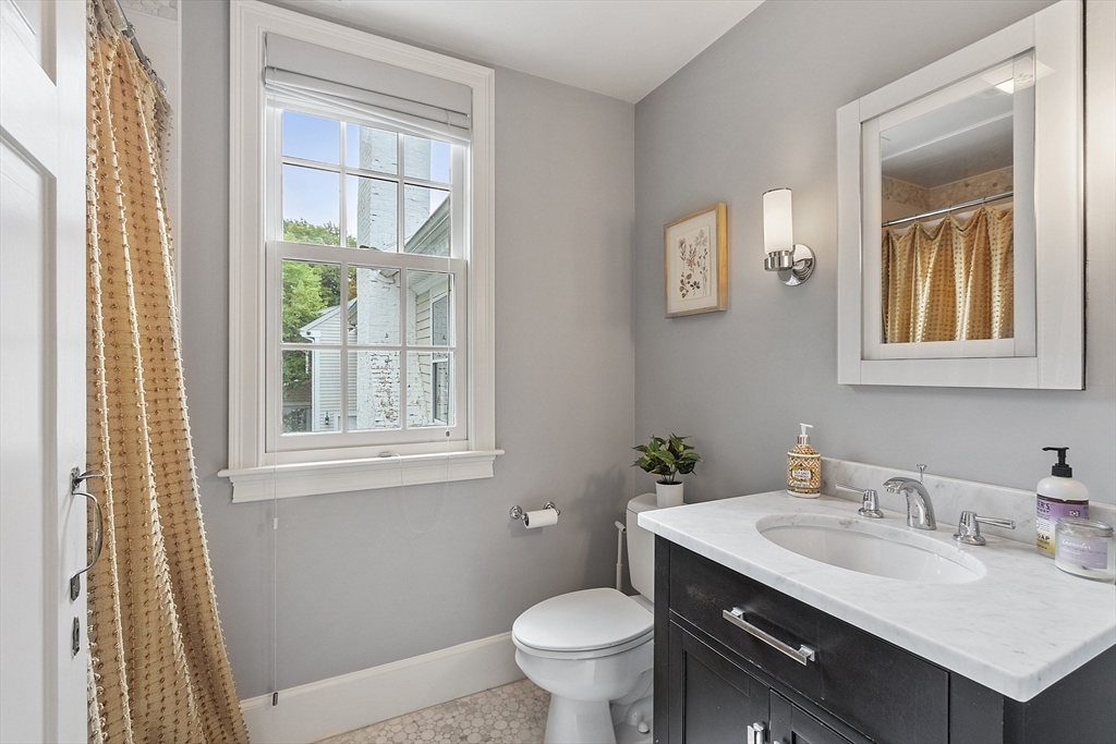 251 A Old Billerica Road Bedford, MA 01730 - Photo 21 of 36 a bathroom with a granite countertop toilet a sink and a mirror