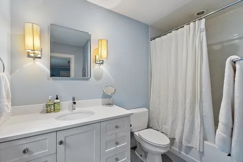 a bathroom with a toilet a sink and a mirror