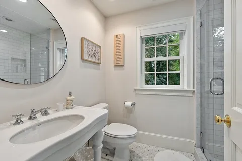 a bathroom with a toilet sink and mirror