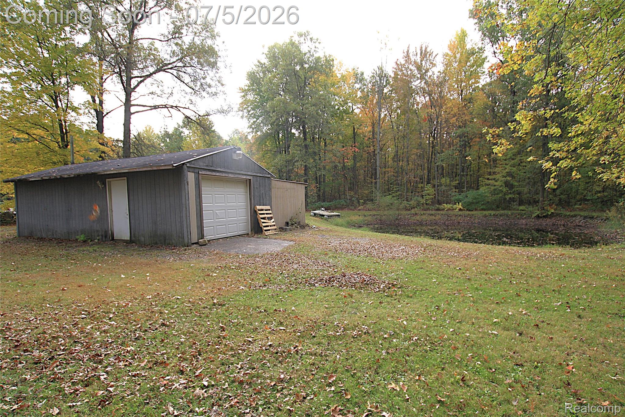 12403 Willard Road Montrose, MI 48457 - Photo 9 of 30 View of grassy yard featuring an outbuilding and a detached garage