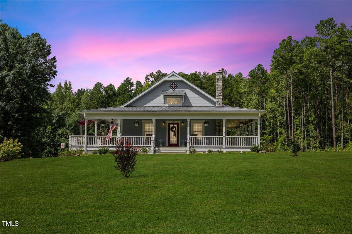 a front view of a house with a garden and trees