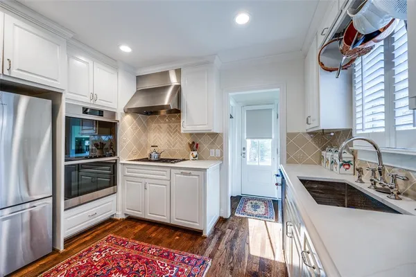 a kitchen with stainless steel appliances a stove a sink and a refrigerator