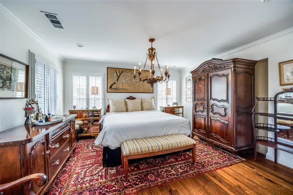 a spacious bedroom with a bed a dresser and windows