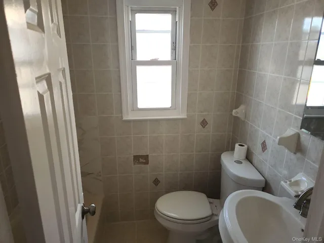 a white toilet sitting next to a bathroom sink and a shower
