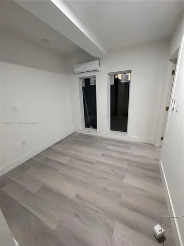 a view of a sink and an empty room with wooden floor