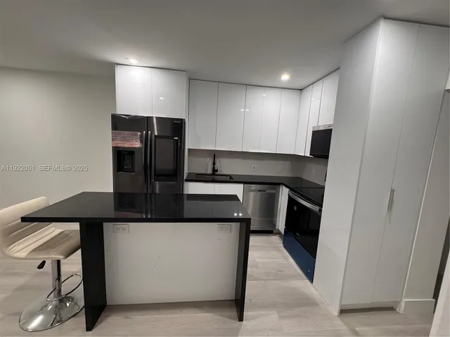 a kitchen with stainless steel appliances granite countertop a refrigerator a sink and a stove