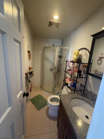 a bathroom with a granite countertop sink a mirror and toilet
