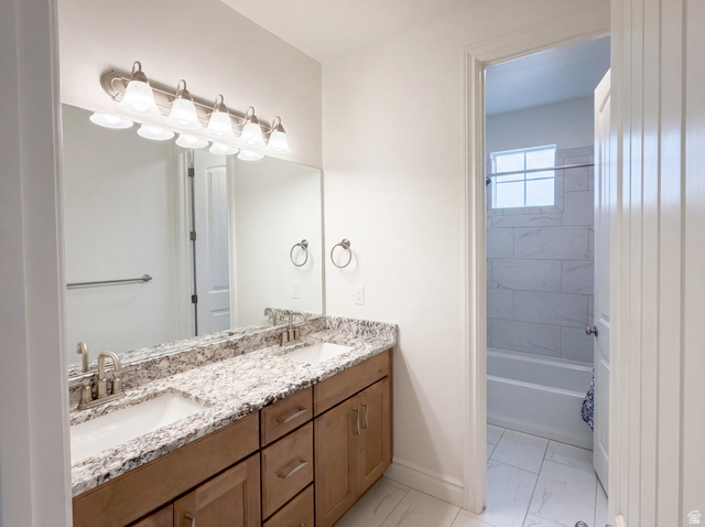1251 North 2525 West Clinton, UT 84015 - Photo 19 of 30 Bathroom vanity featuring dual undermount sinks set in a stone countertop with wood-finish cabinetry