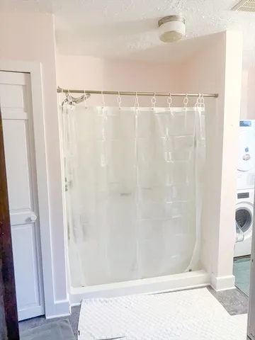 a view of a hallway with wooden floor and a bathroom
