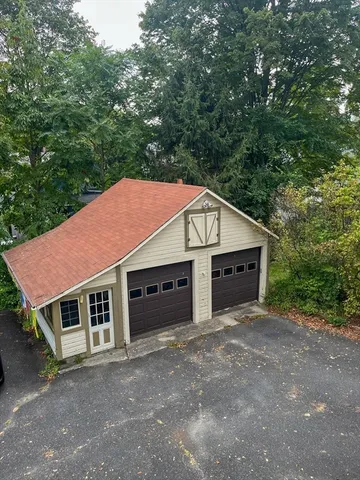 a view of a house with a yard and large tree
