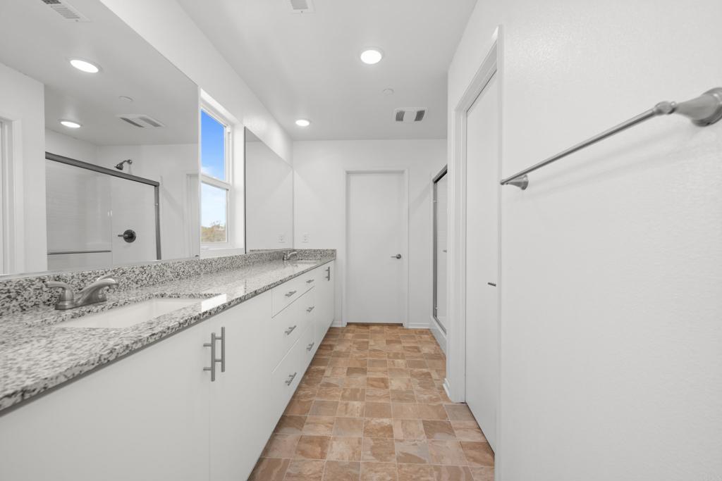 34742 Criollo Way Fallbrook, CA 92028 - Photo 19 of 28 a bathroom with a granite countertop sink a large mirror and a shower