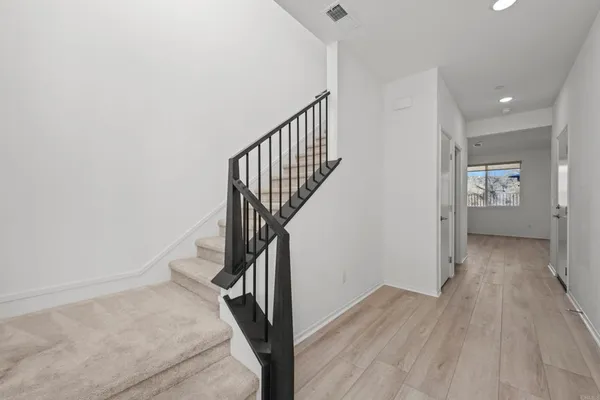 a view of a hallway with wooden floor and entryway