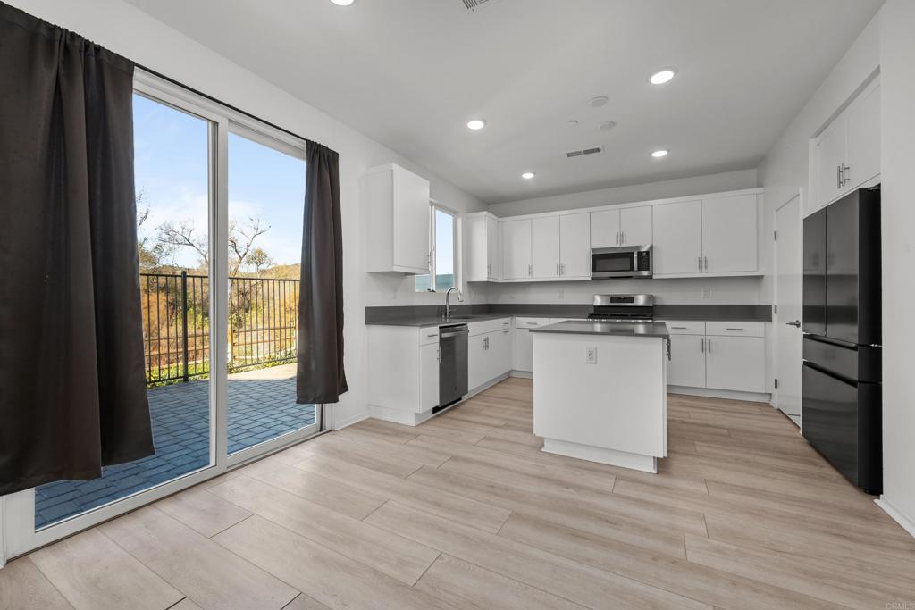 34742 Criollo Way Fallbrook, CA 92028 - Photo 8 of 28 a kitchen with a refrigerator a stove top oven and a granite counter top