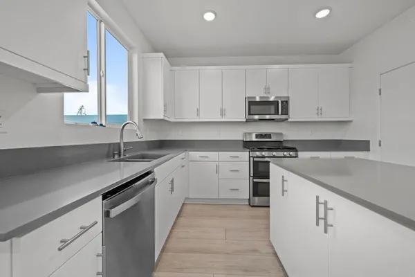 a kitchen with cabinets appliances a sink and a counter top space