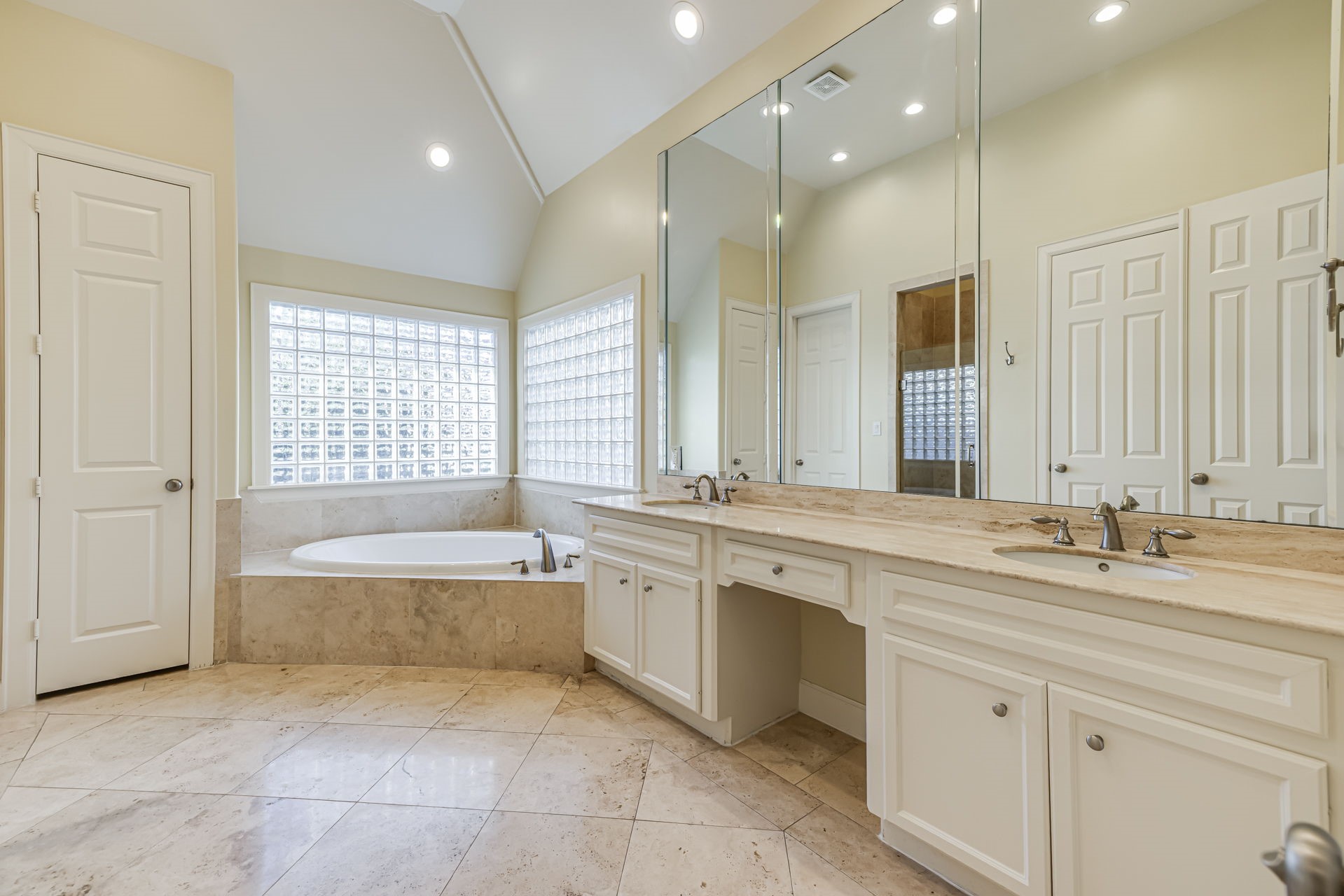 6310 Hermann Lake Drive Houston, TX 77021 - Photo 16 of 39 Spa-like primary bath with dual vanity sinks, make-up cabinet, jetted tub, and walk-in shower.