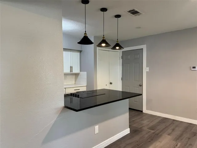 a kitchen with kitchen island a stove and a wooden floor