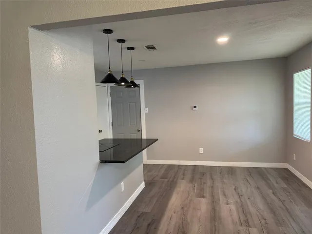 a view of a room with wooden floor and a ceiling fan
