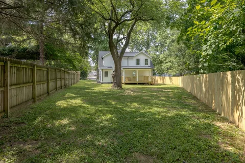 a view of a house with a yard and wooden fence