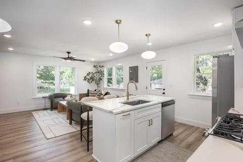 a kitchen with stainless steel appliances granite countertop a sink stove and refrigerator