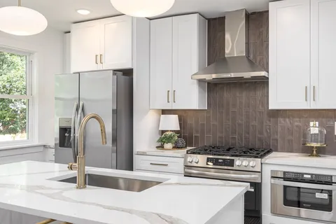 a kitchen with stainless steel appliances granite countertop a stove and a wooden floors