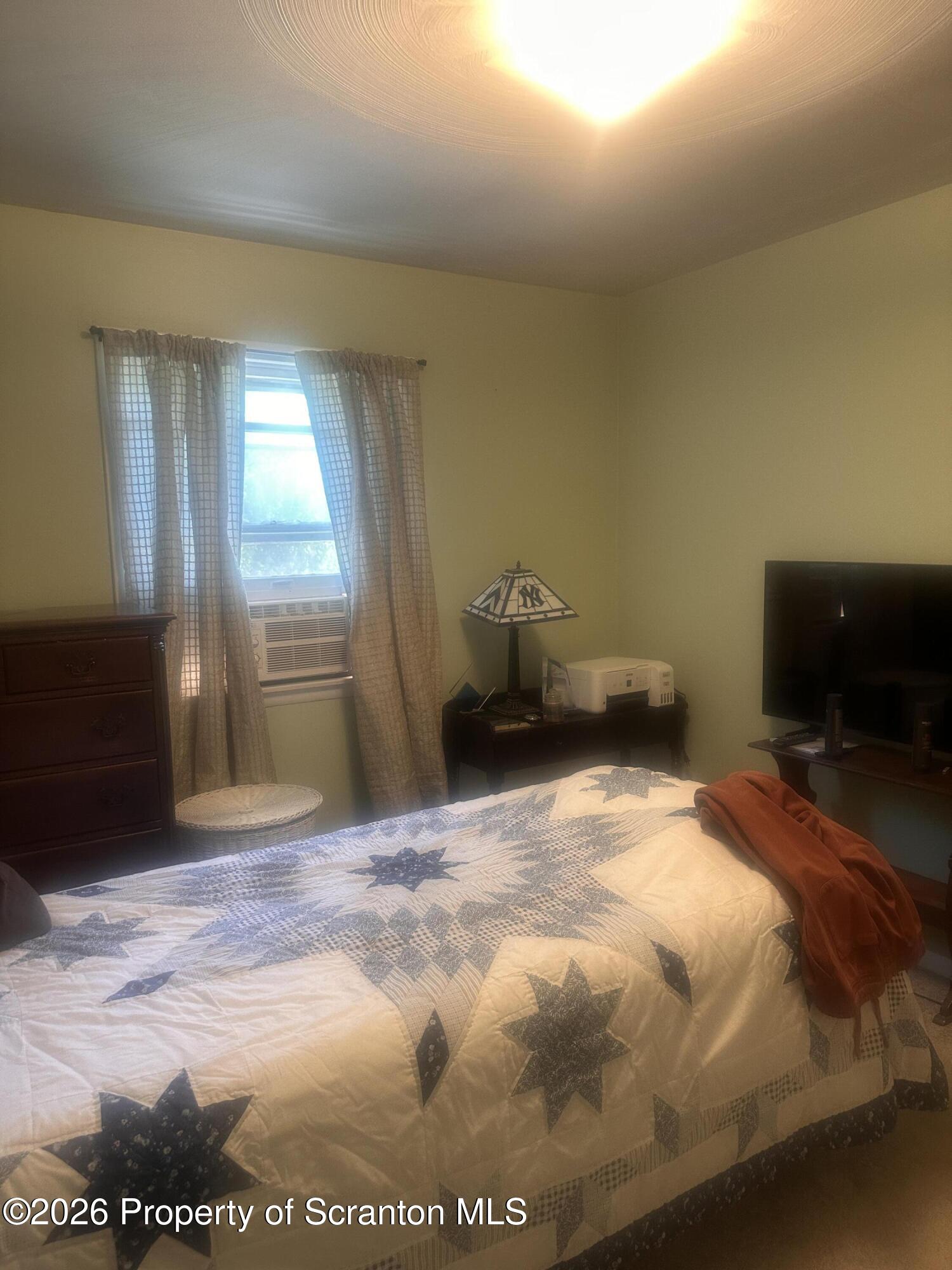 107 Keystone Hls Road, Unit 405 Factoryville, PA 18419 - Photo 24 of 27 a bedroom with a bed and a flat screen tv