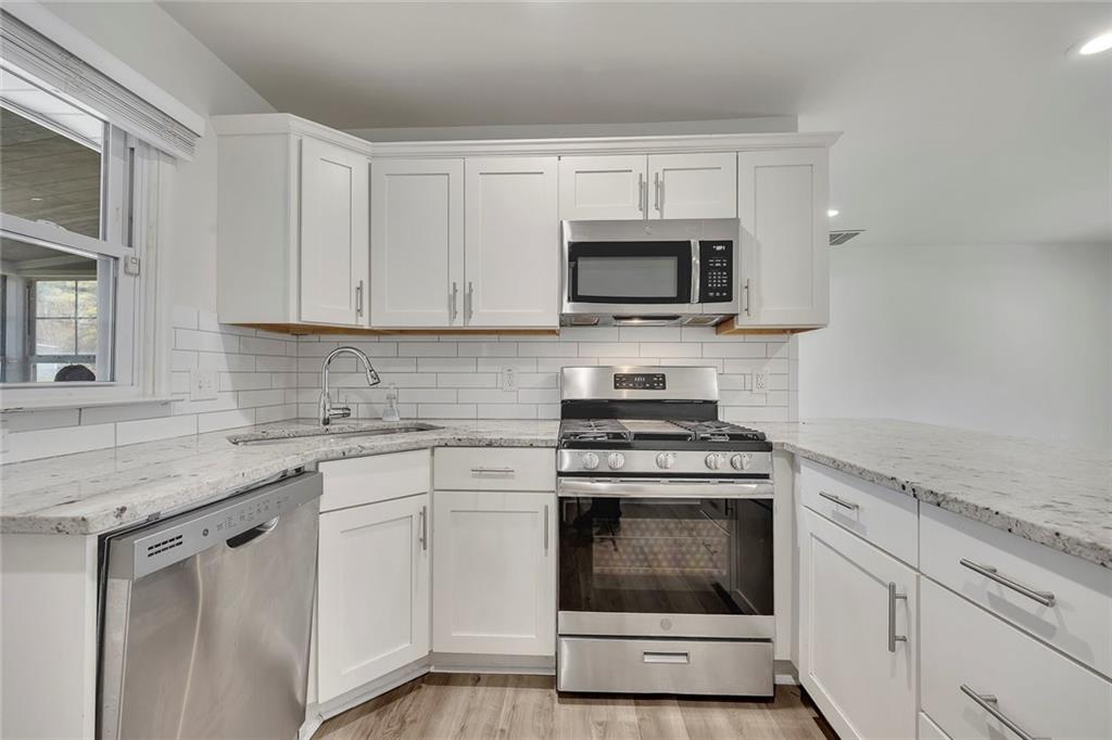 3940 Forrest Court Chamblee, GA 30341 - Photo 11 of 35 a kitchen with white cabinets and stainless steel appliances