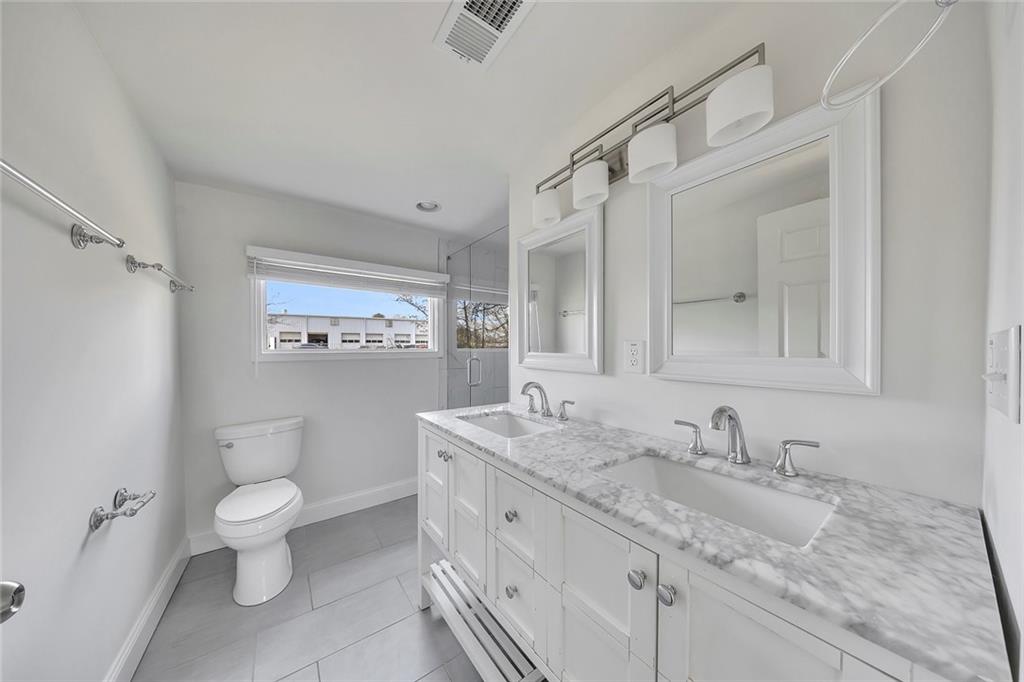 3940 Forrest Court Chamblee, GA 30341 - Photo 16 of 35 a bathroom with a granite countertop sink a toilet and a mirror