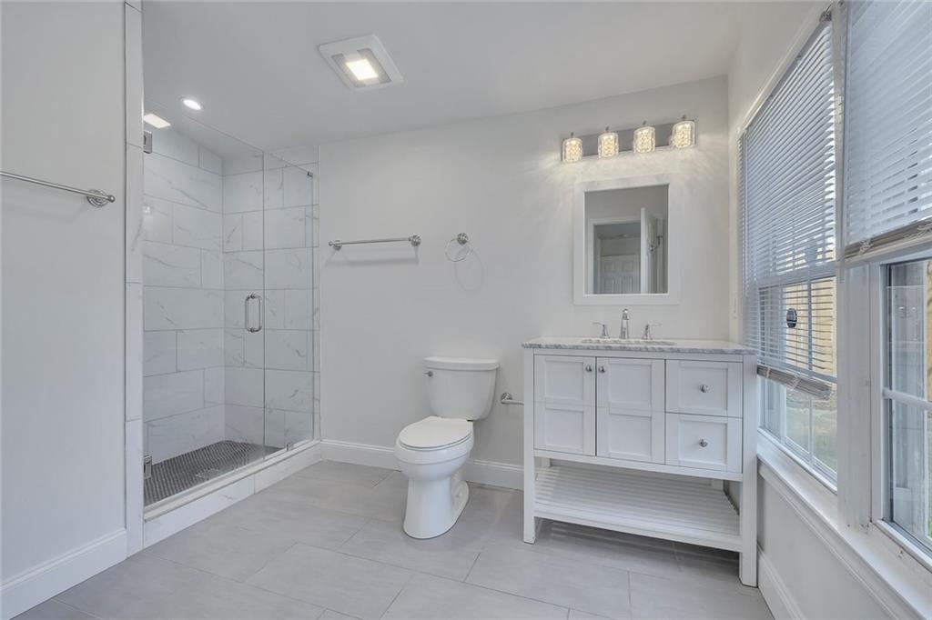 3940 Forrest Court Chamblee, GA 30341 - Photo 21 of 35 a bathroom with a toilet sink and shower