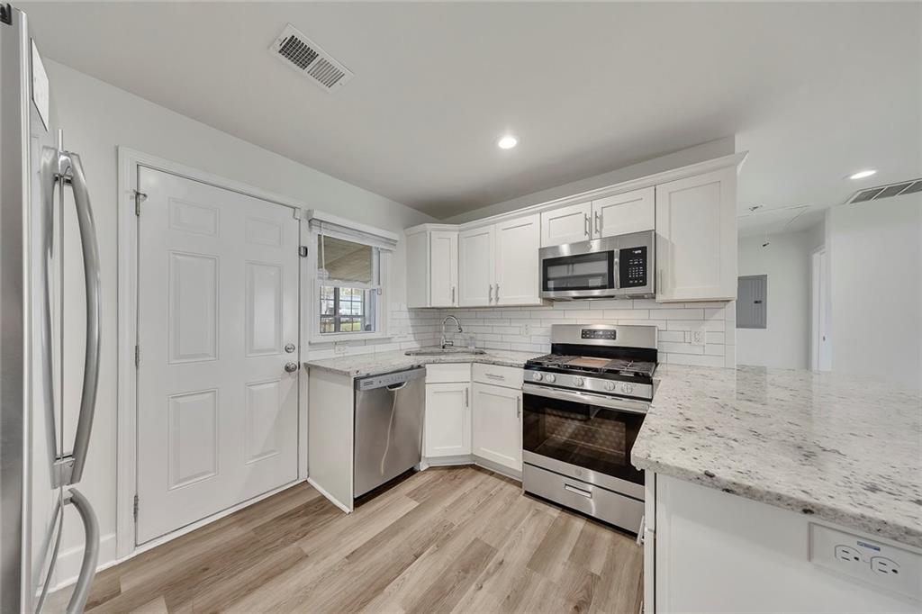 3940 Forrest Court Chamblee, GA 30341 - Photo 10 of 35 a kitchen with granite countertop a stove top oven and sink