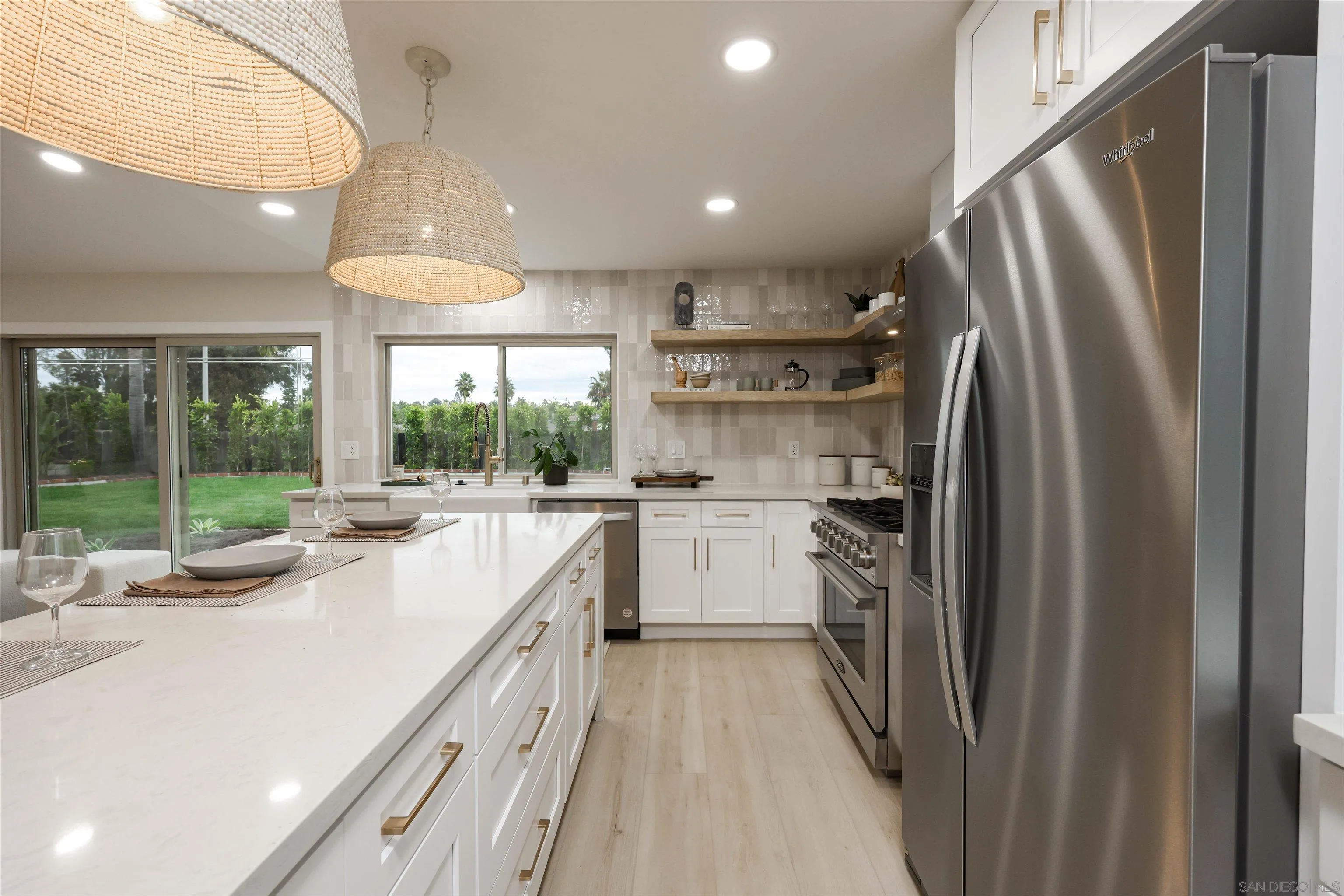 837 Elmview Drive Encinitas, CA 92024 - Photo 16 of 27 a kitchen with refrigerator a sink and white cabinets