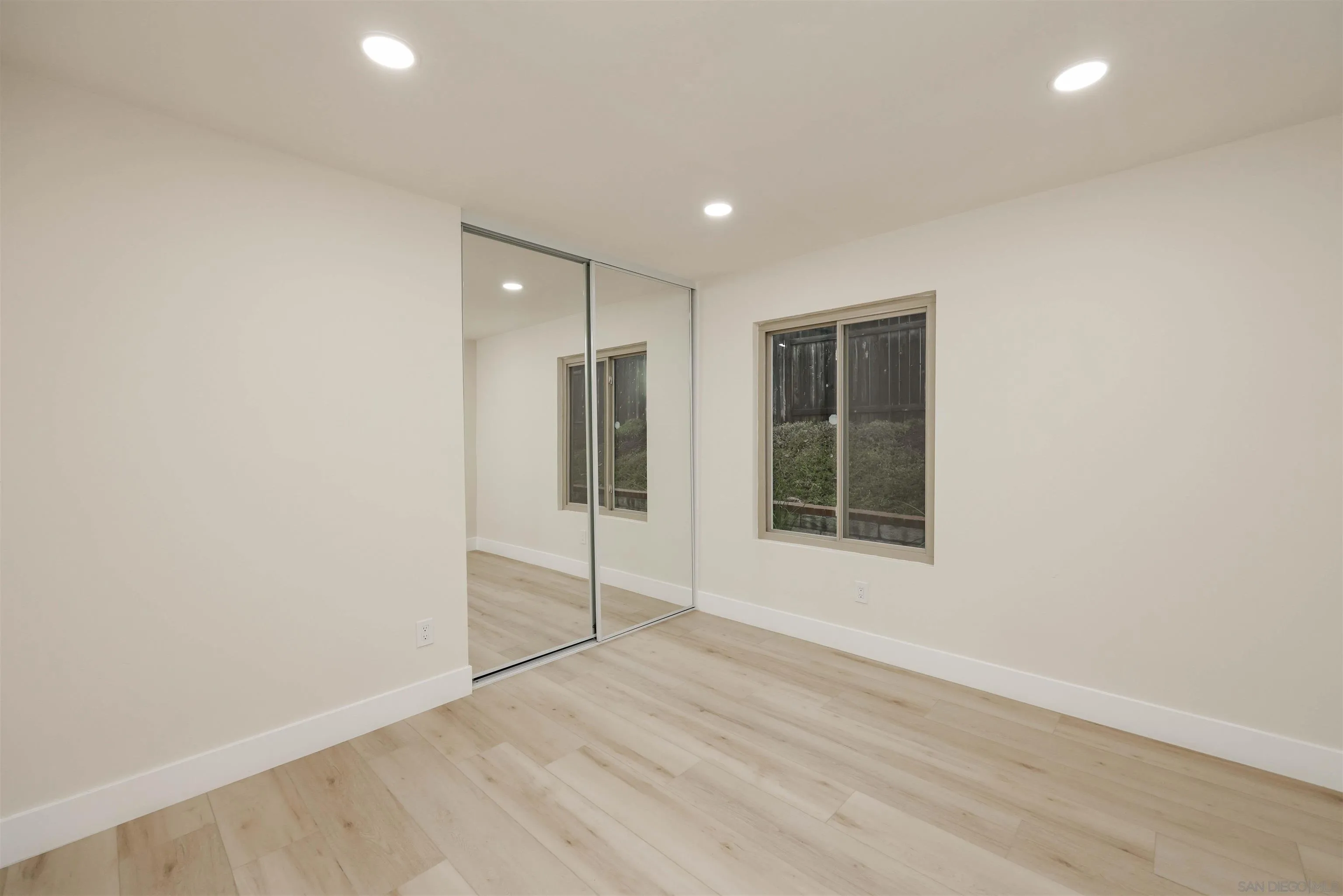 837 Elmview Drive Encinitas, CA 92024 - Photo 19 of 27 an empty room with wooden floor and windows