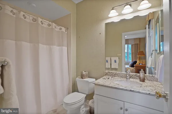 a kitchen with stainless steel appliances kitchen island granite countertop a refrigerator a stove a sink and a dining table with wooden floor