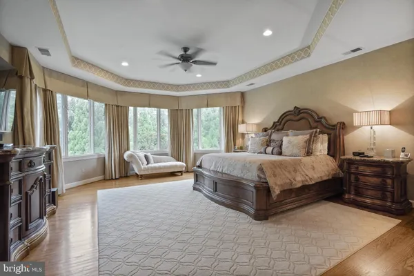 a dining room with chandelier and wooden floor