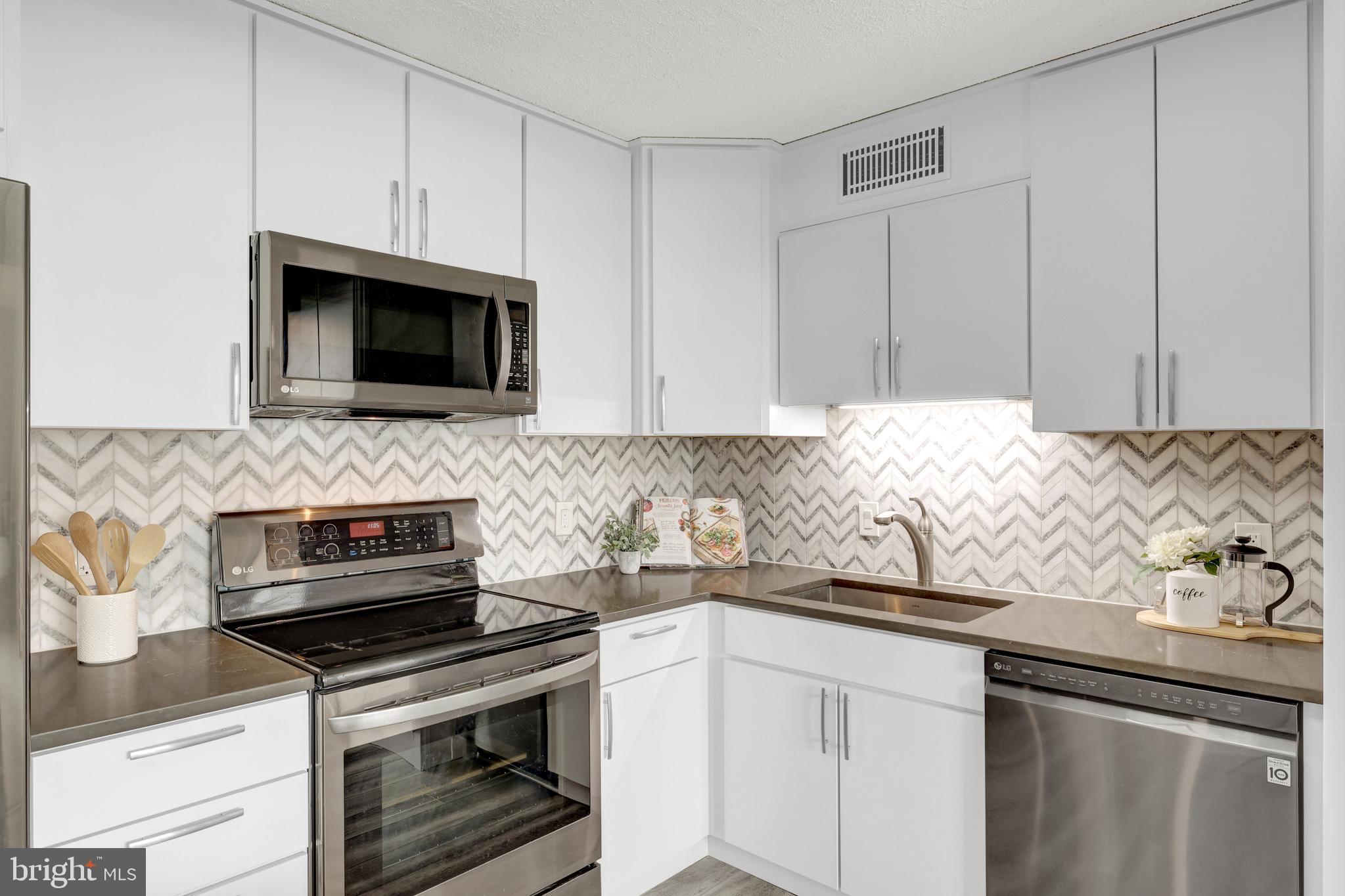 6800 Fleetwood Road, Unit 810 McLean, VA 22101 - Photo 3 of 30 a kitchen with granite countertop white cabinets and stainless steel appliances