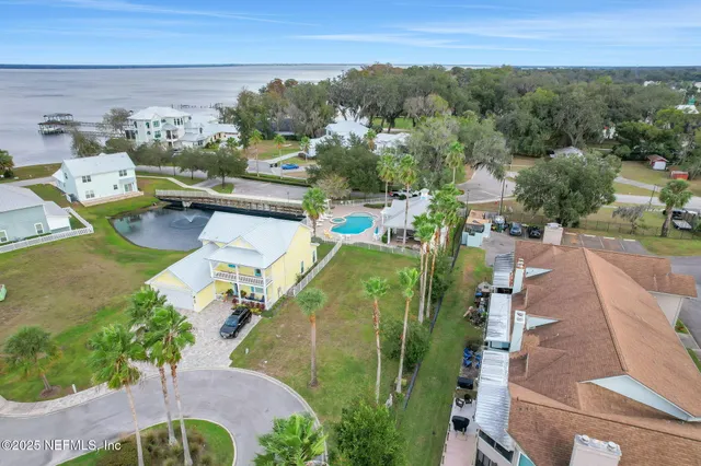 an aerial view of residential houses with outdoor space and trees