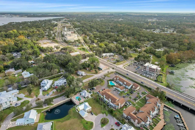 an aerial view of a house with a yard and lake view