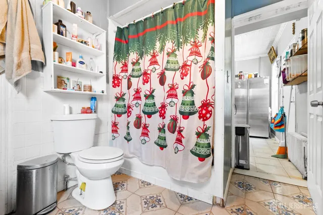 a bathroom with a toilet and a shower curtain