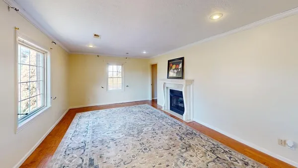 a view of an empty room with a fireplace and a window