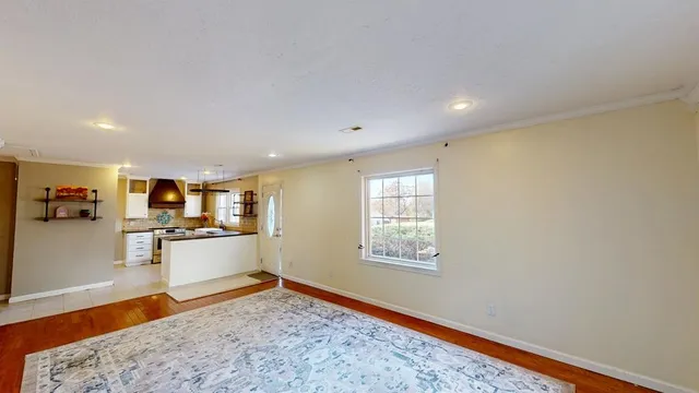 a view of a kitchen with wooden floor and a window