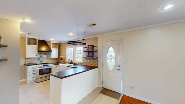 a kitchen with stainless steel appliances granite countertop a refrigerator a stove and a sink