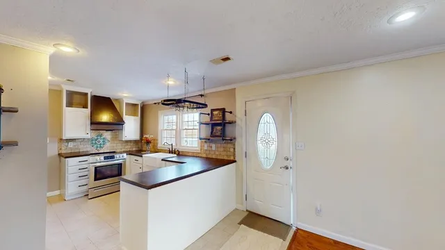 a kitchen with stainless steel appliances granite countertop a refrigerator a stove and a sink