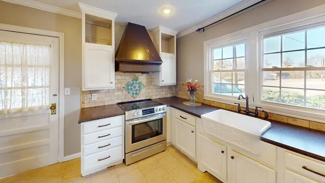 a kitchen with granite countertop a sink a stove and cabinets
