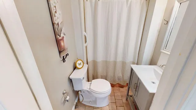 a white toilet sitting next to a bath tub