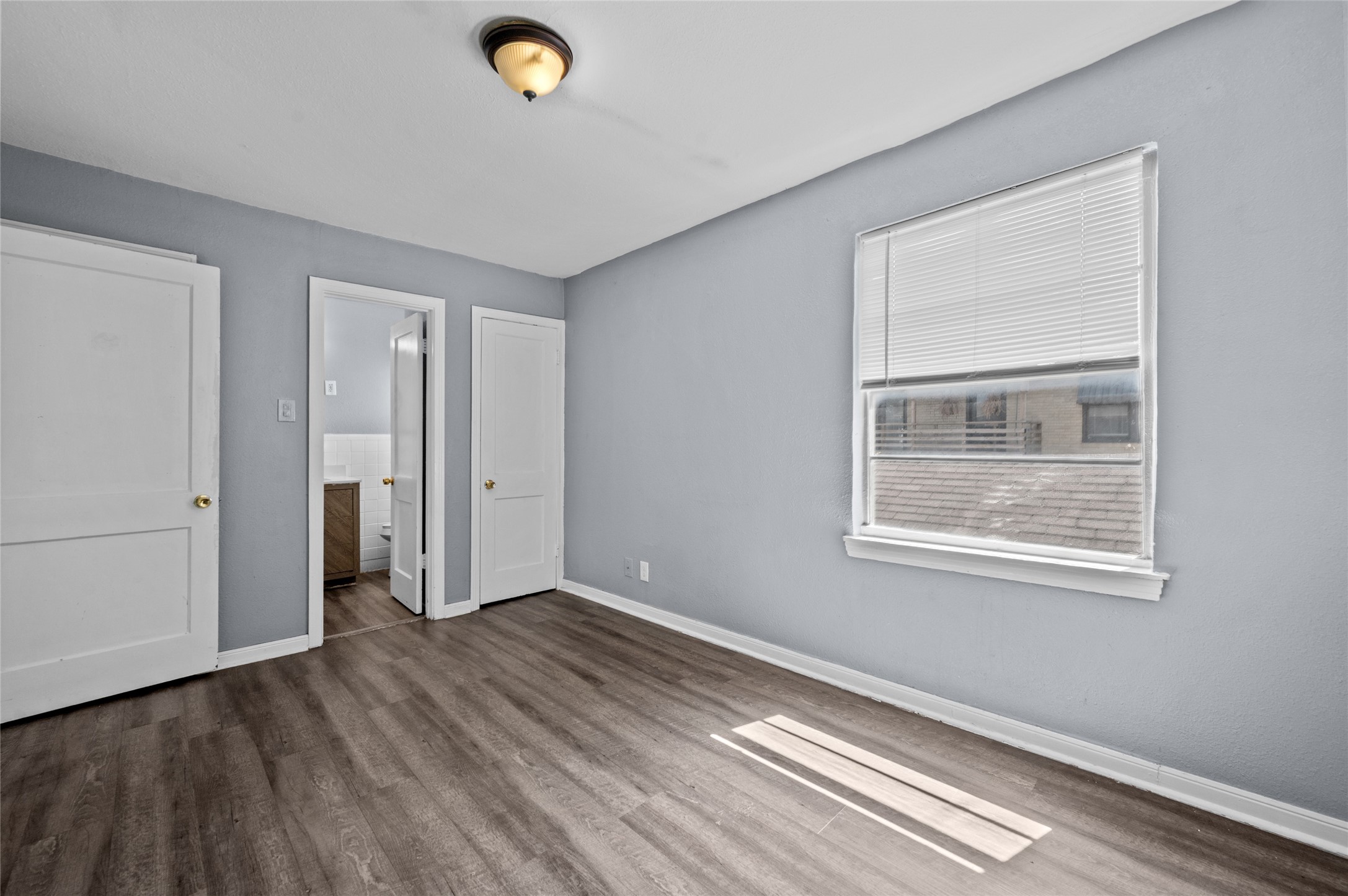 1919 McDuffie Street, Unit 2 Houston, TX 77019 - Photo 3 of 12 a view of an empty room with wooden floor and a window