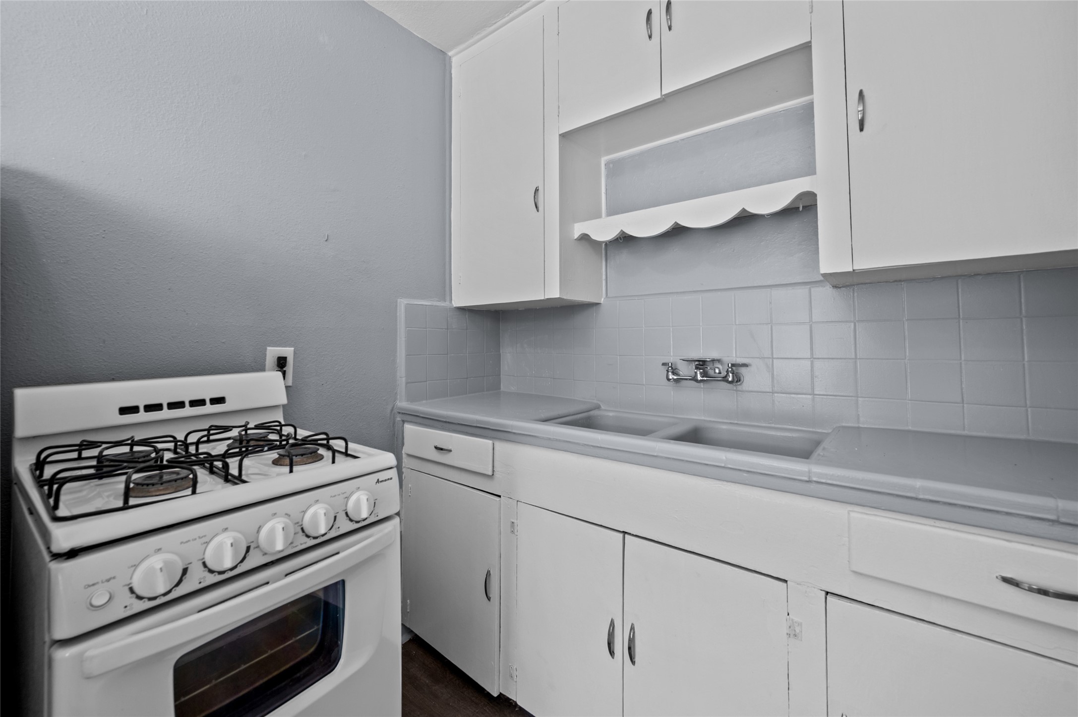 1919 McDuffie Street, Unit 2 Houston, TX 77019 - Photo 10 of 12 a kitchen with white cabinets stainless steel appliances and wooden floor