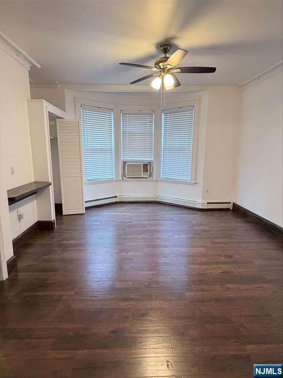 a view of an empty room with wooden floor and window