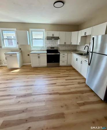 a kitchen with stainless steel appliances granite countertop a stove and a refrigerator