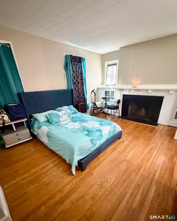 a bedroom with a bed and wooden floor