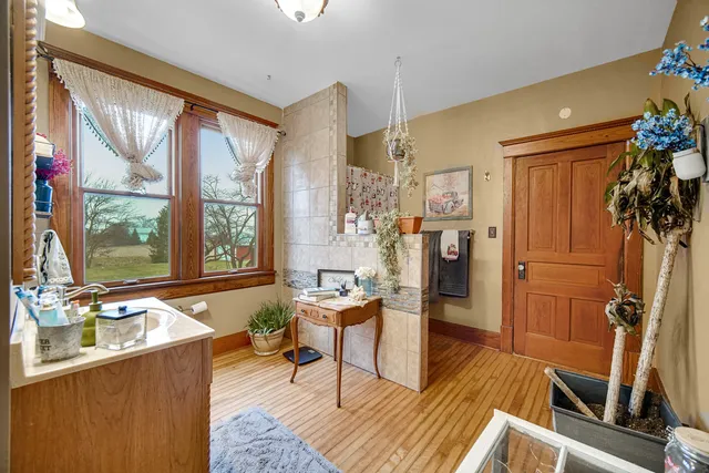 a living room with furniture large window and wooden floor